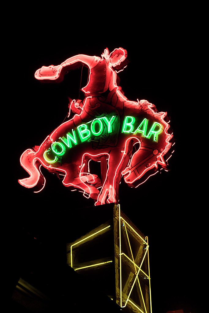 The neon bucking-bronco sign of the Million Dollar Cowboy Bar lit against the night sky